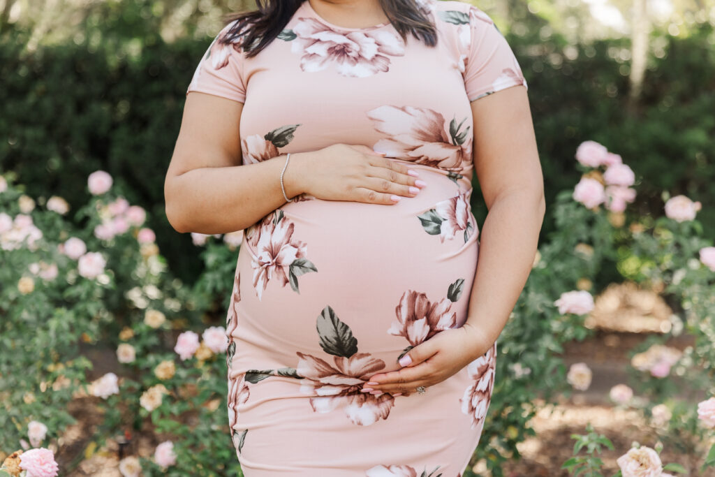 close up of the baby bump in a rose garden during Maternity photo session
